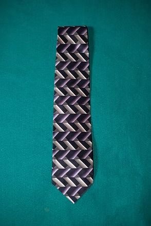 Purple patterned necktie on a teal background