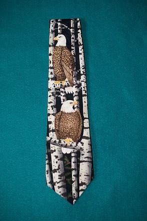 Black necktie with birch trees and two birds on a teal background