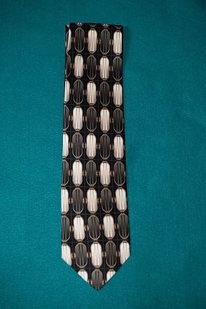 Black necktie with white geometric pattern on a teal background