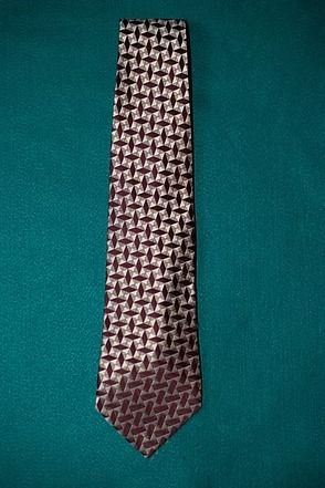 Brown patterned necktie on a teal background