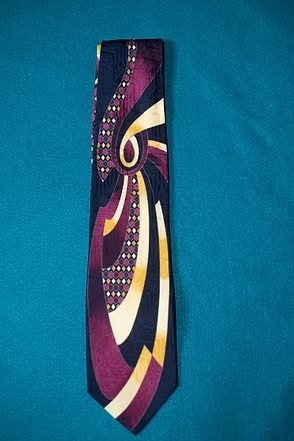Abstract purple, gold, and cream necktie on a teal background.