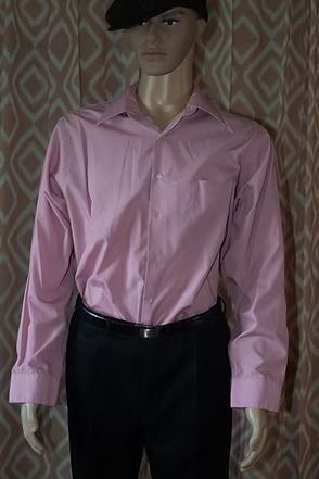 Mannequin wearing a pink button-down shirt, black pants, and a black cap against patterned curtains