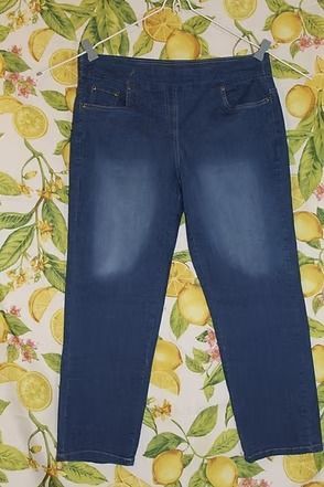 Blue denim jeans laid flat on a patterned floral background.