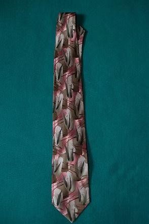 Patterned pink and gray necktie on a teal background