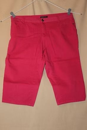 Bright pink shorts clipped to a hanger against a beige background.
