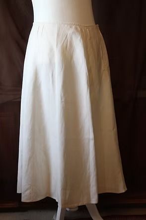 White sheer ankle-length skirt hanging against a dark background