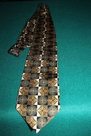 Patterned necktie with brown and gold geometric design on a green background