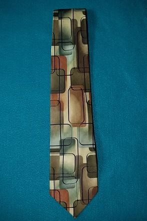 Abstract patterned necktie with brown, tan, blue, and red geometric blocks on a teal background