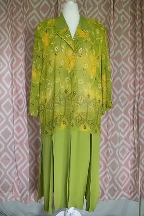 Bright green floral blouse and matching pants displayed on a mannequin against a patterned backdrop