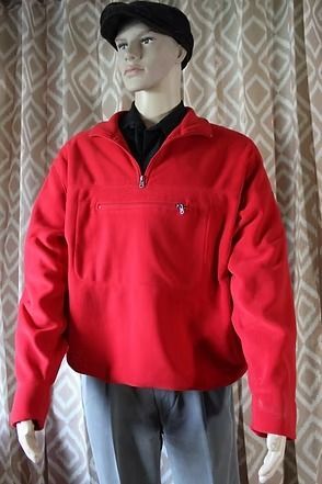 Mannequin wearing a red quarter-zip pullover, gray pants, and black cap in front of patterned curtains