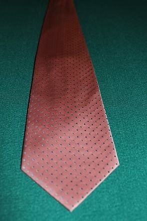 Pink polka dot necktie on a green background