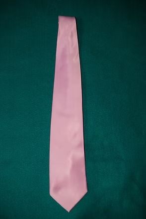 Pink necktie on a dark green background