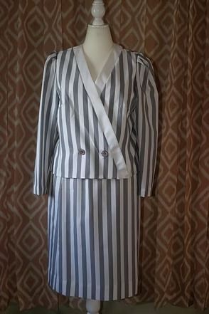 Striped long coat on a mannequin against a patterned curtain.