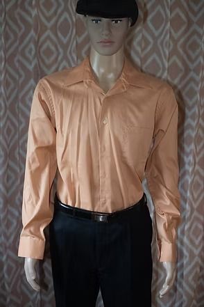 Side-view mannequin in a peach button-up shirt and black pants against patterned curtains
