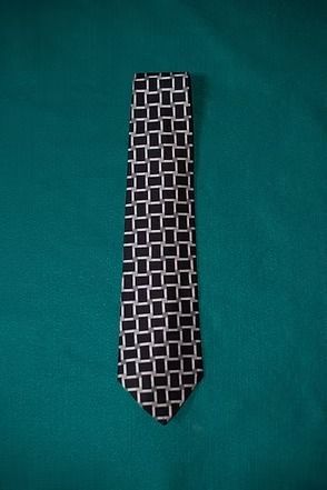 Black tie with a white geometric pattern on a green background