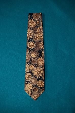 Patterned tie with gold and brown circular designs on a blue background