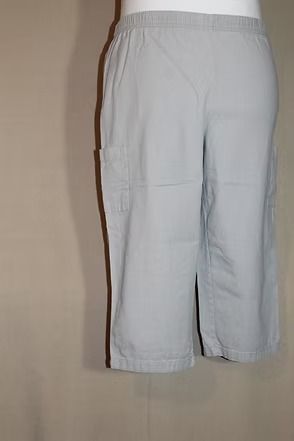 Light gray knee-length shorts hanging against a beige wall.