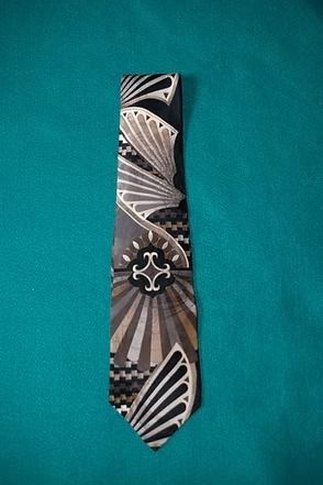 Patterned black and white necktie on a teal background