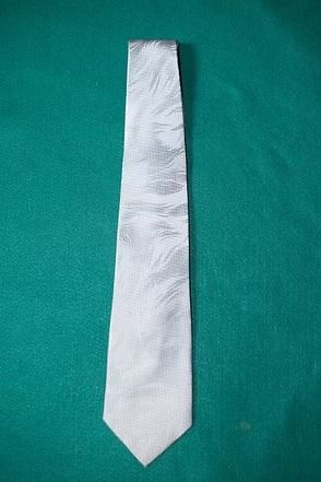 White necktie on a green background