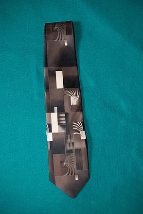 Black patterned necktie on a teal background