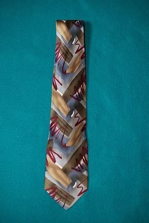 Patterned multicolor necktie on a teal background