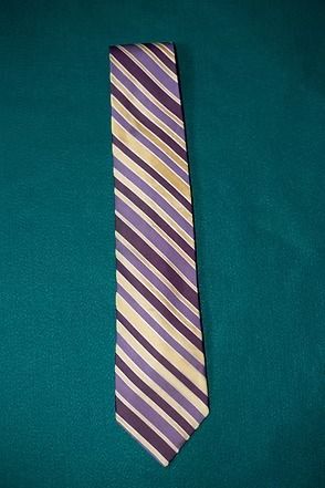 Purple and cream striped necktie on a teal background