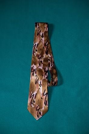 Brown patterned necktie on a teal background