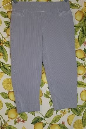 Gray pinstriped pants laid flat on a lemon-patterned surface.