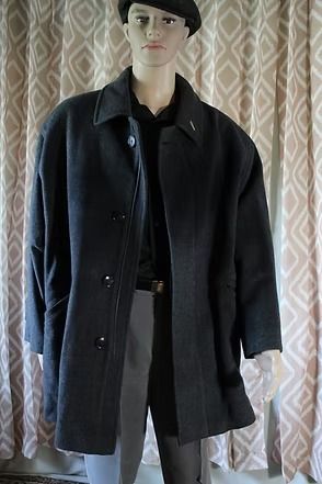 Mannequin wearing a black coat and beret against patterned curtains
