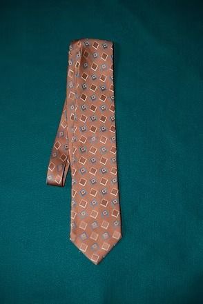 Orange patterned necktie on a dark green background