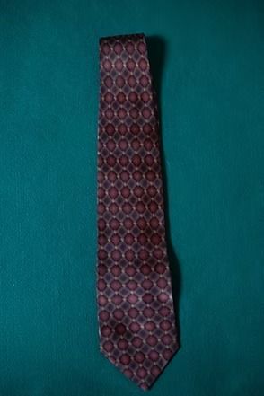 Patterned maroon tie on a teal background