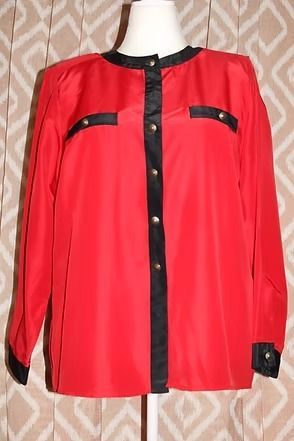 Red long-sleeve button-up blouse with black trim on a mannequin, front view