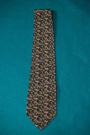 Brown patterned necktie on a teal background