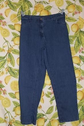 Dark blue jeans laid flat on a patterned floral background.