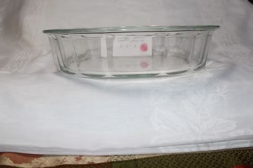 Clear glass baking dish on a white cloth background.