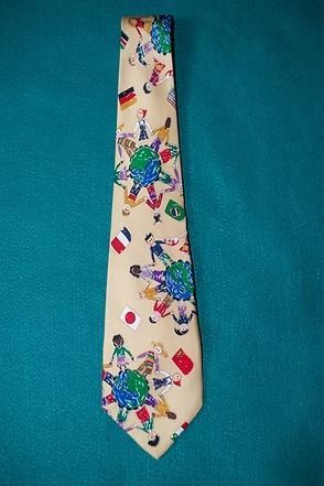 Cream necktie with colorful floral and geometric pattern on a teal background