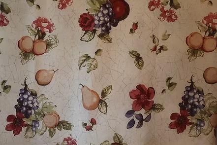 Floral fabric with peaches, grapes, and roses on a light beige background