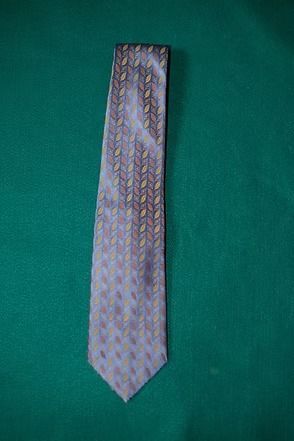 Patterned light gray tie on a green background