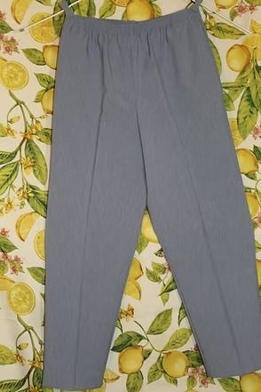 Gray pants laid flat on a lemon-patterned fabric background.