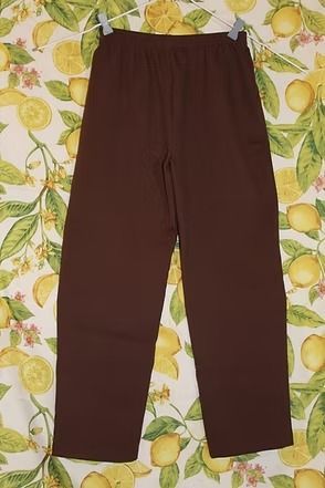 Brown pants laid flat on a yellow-and-green floral background.