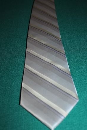 Gray and white striped necktie on a teal textured background