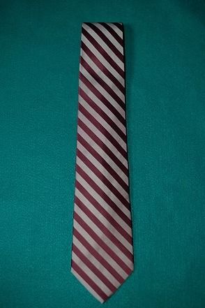 Red and white striped necktie on a teal background