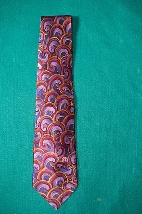Colorful paisley-patterned necktie on a teal background