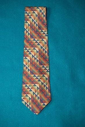Multicolored patterned necktie on a teal background