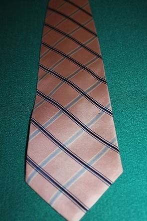 Pink and blue striped necktie on a teal background
