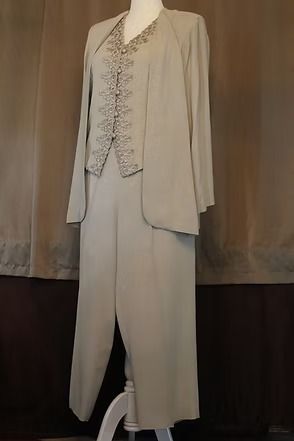 Beige tailored jacket and wide-leg pants displayed on a mannequin against a brown backdrop