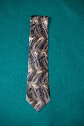 Silver patterned necktie on a teal background