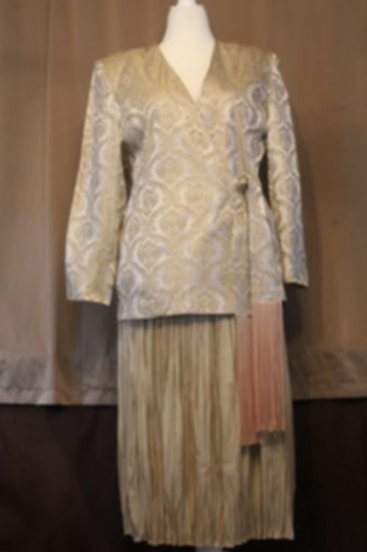 Beige patterned jacket with matching pleated skirt on a mannequin