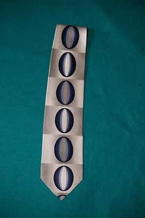 White tie with blue oval pattern on a teal background
