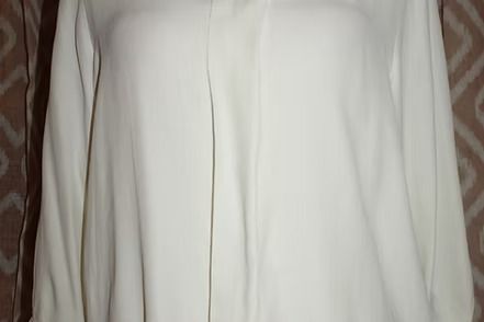 Close-up of a white curtain with vertical folds and seams